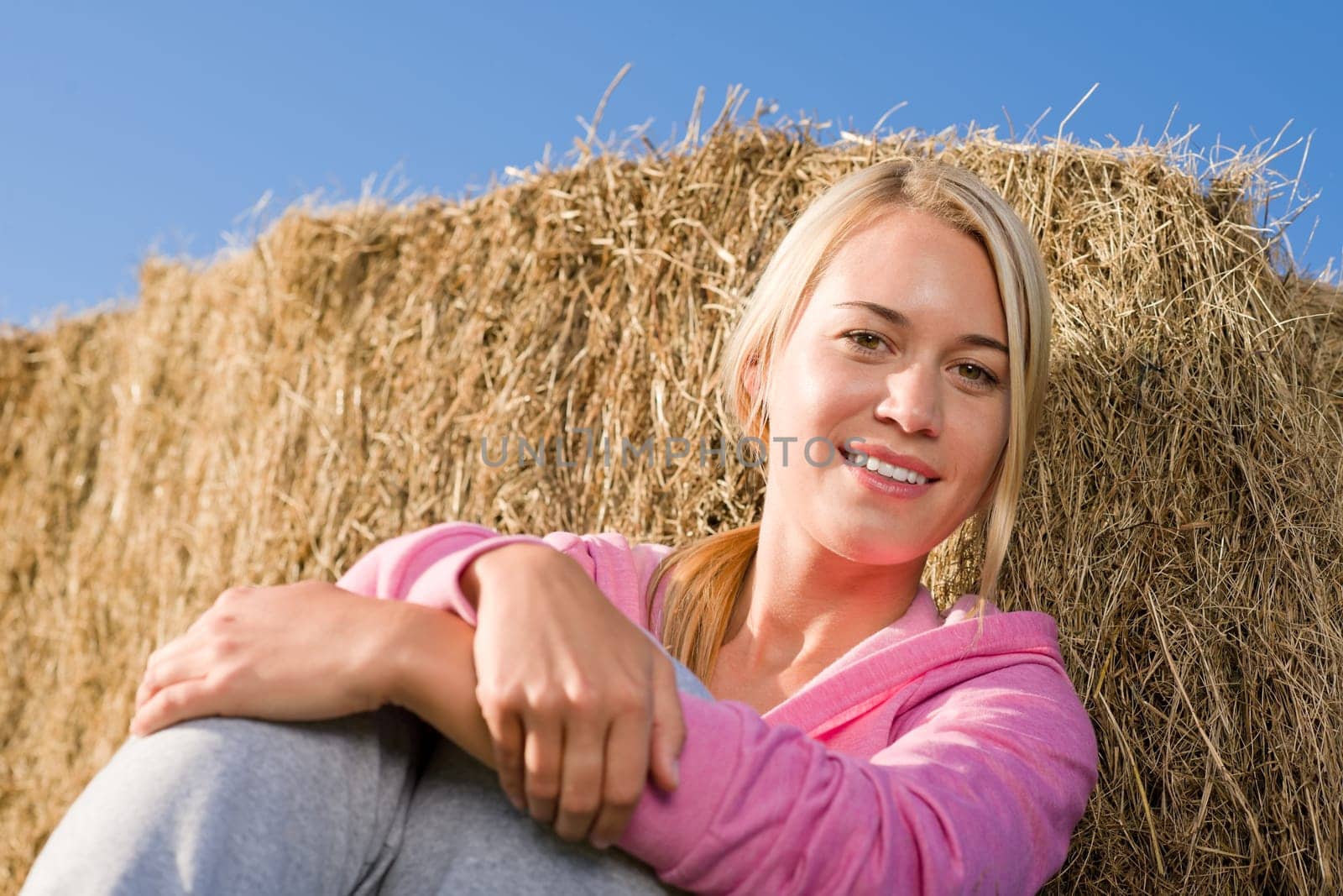 Sportive young woman relax lean against hay bales sunset countryside