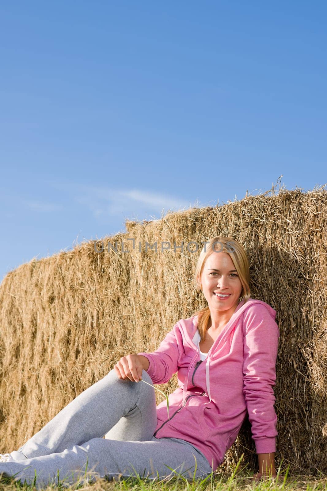 Sportive young woman relax lean against hay bales sunset countryside