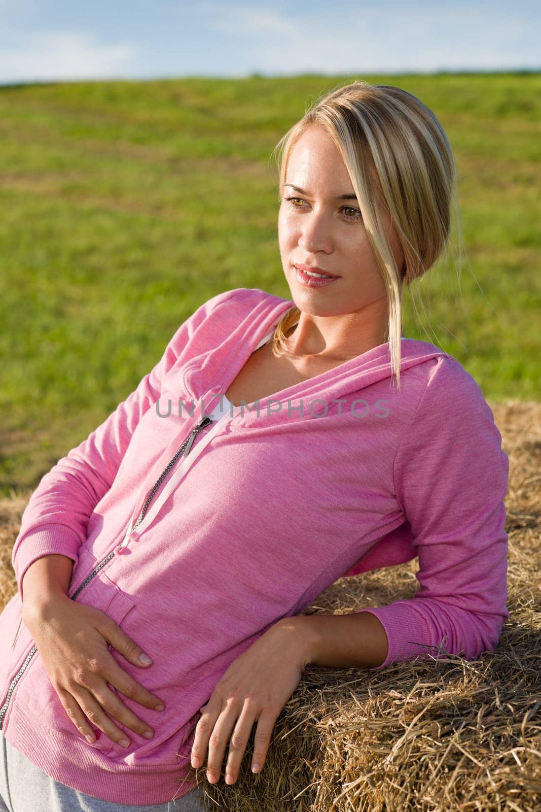 Portrait of sportive young woman relax lean against hay bales