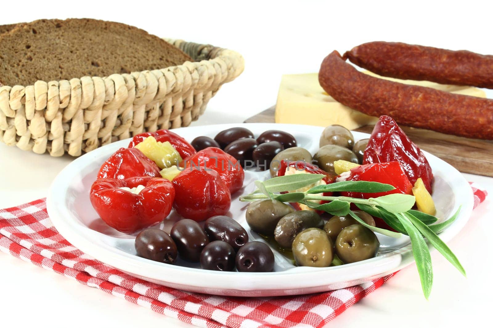 Olives and stuffed pepperoni on a white plate