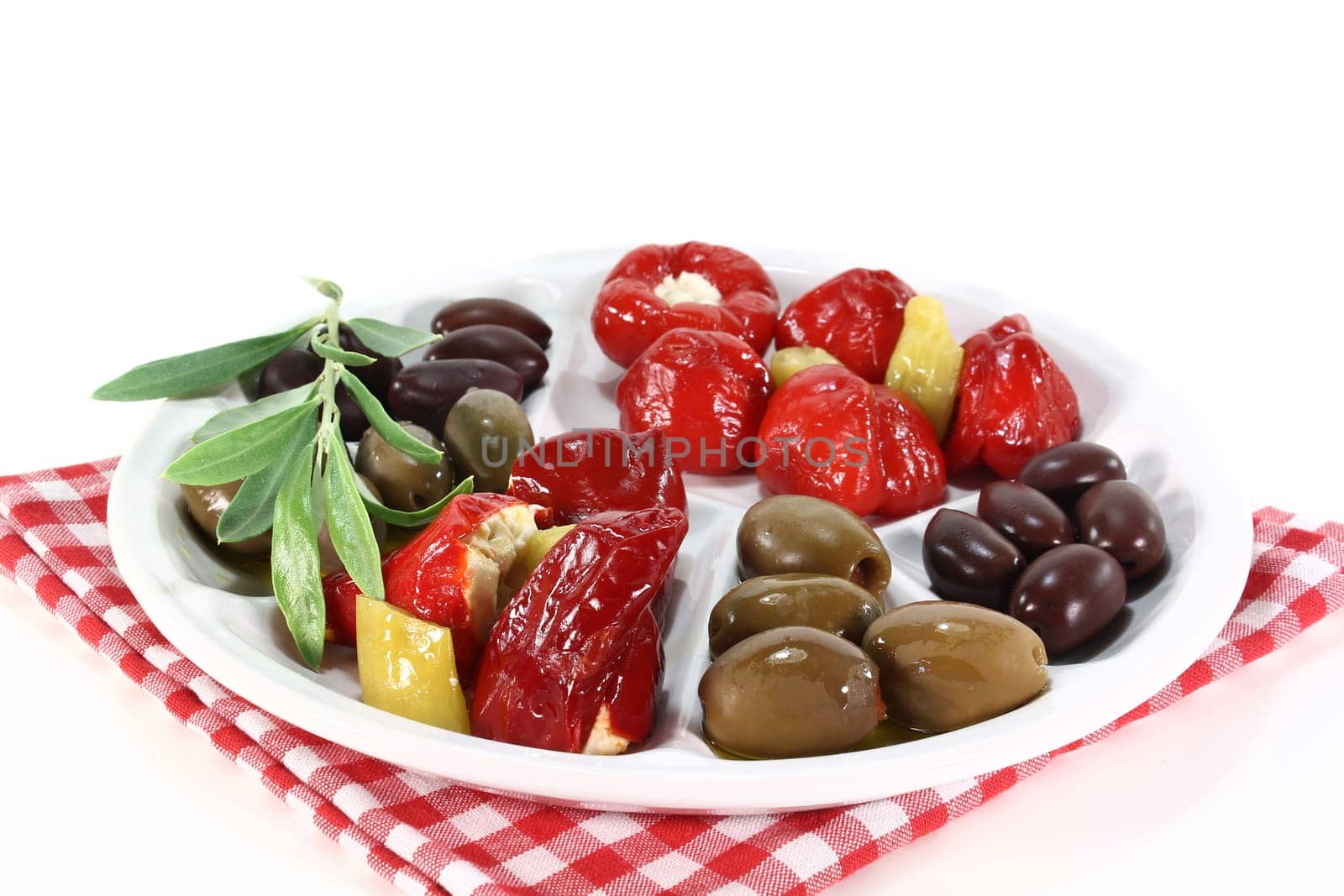 Olives and stuffed pepperoni on a white plate