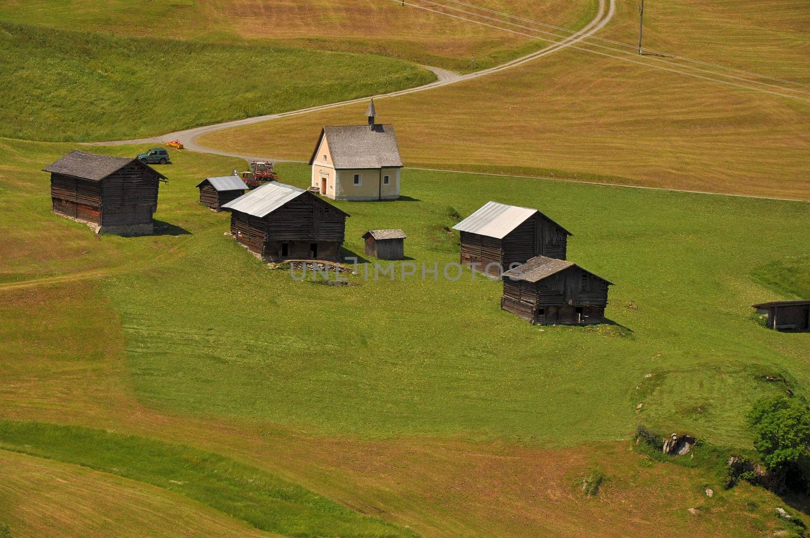 landscape with mountain huts and small chapel in swiss alpine valley