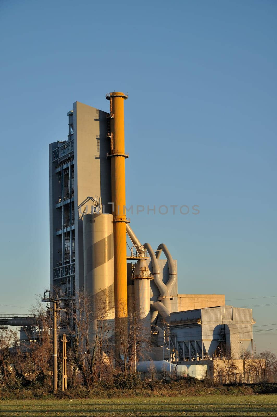 foreshortening of cement industrial plant, shot in in winter windy and sunny weather in plains of lombardy near bergamo