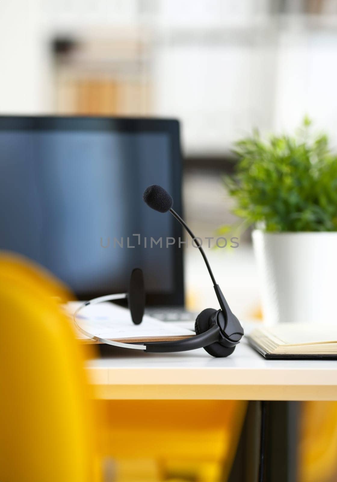 Empty remote office workplace with laptop pc and headset closeup. Receptionist or secretary of contact data center desktop keyboard device desk table ip telephony or callcenter voice message system