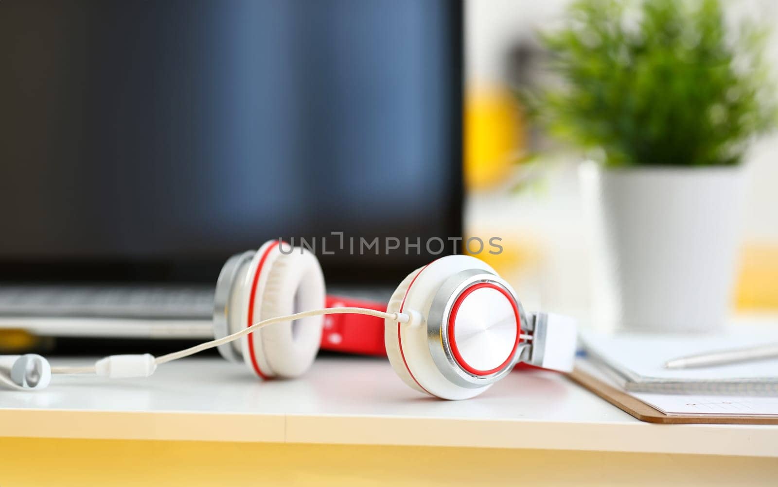 Empty remote office workplace with laptop pc and headset closeup. Receptionist or secretary of contact data center desktop keyboard device desk table ip telephony or callcenter voice message system