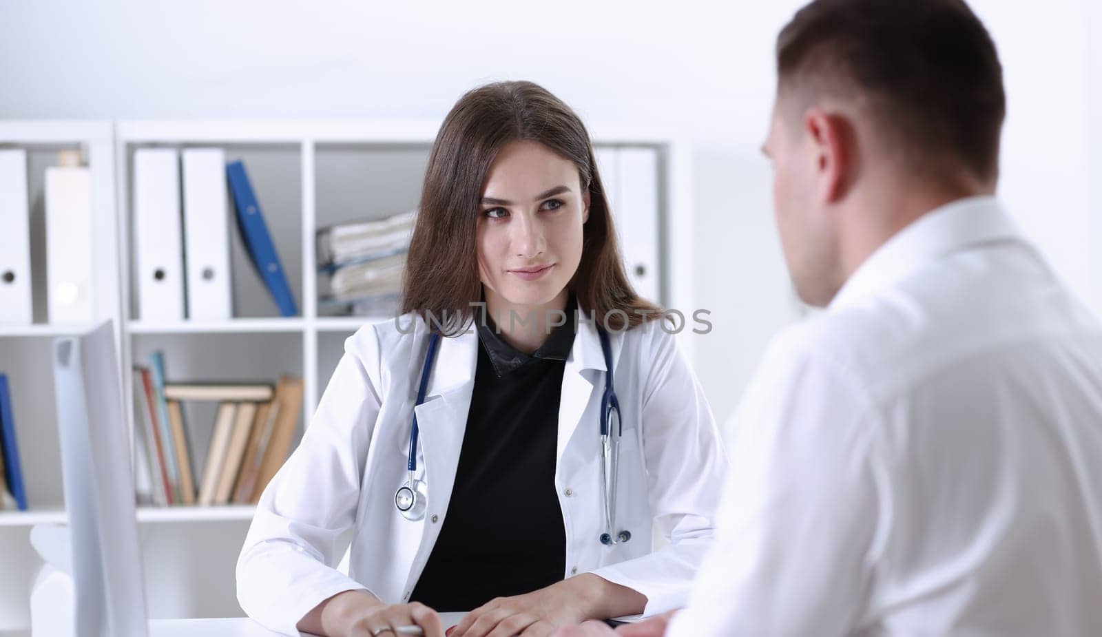 Beautiful smiling female doctor hold silver pen filling patient history list at clipboard pad. Physical exam er disease prevention ward round 911 prescribe remedy healthy lifestyle concept