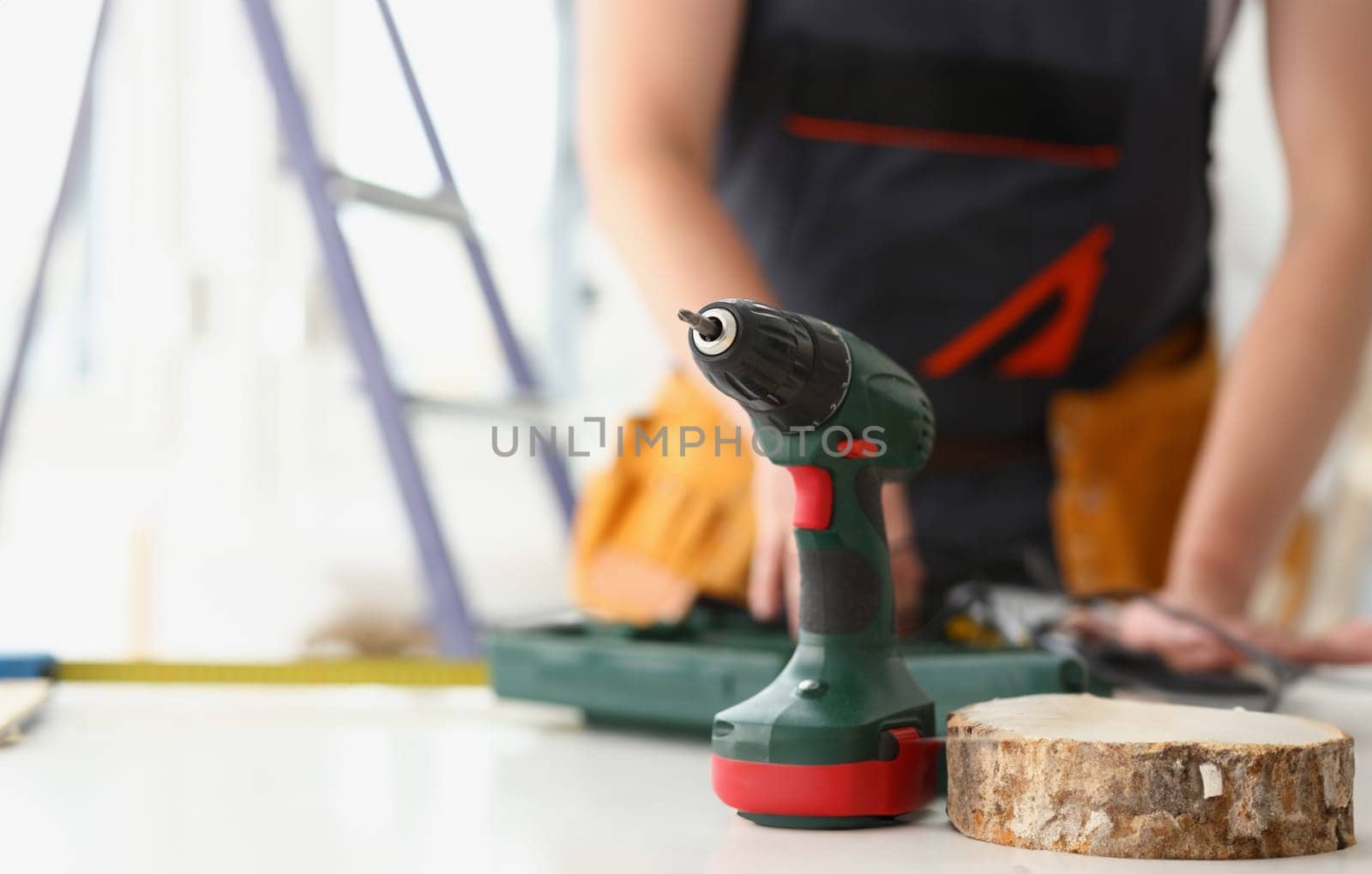 Arms of worker using electric drill closeup. Manual job DIY inspiration improvement job fix shop yellow helmet joinery startup idea industrial education profession career concept