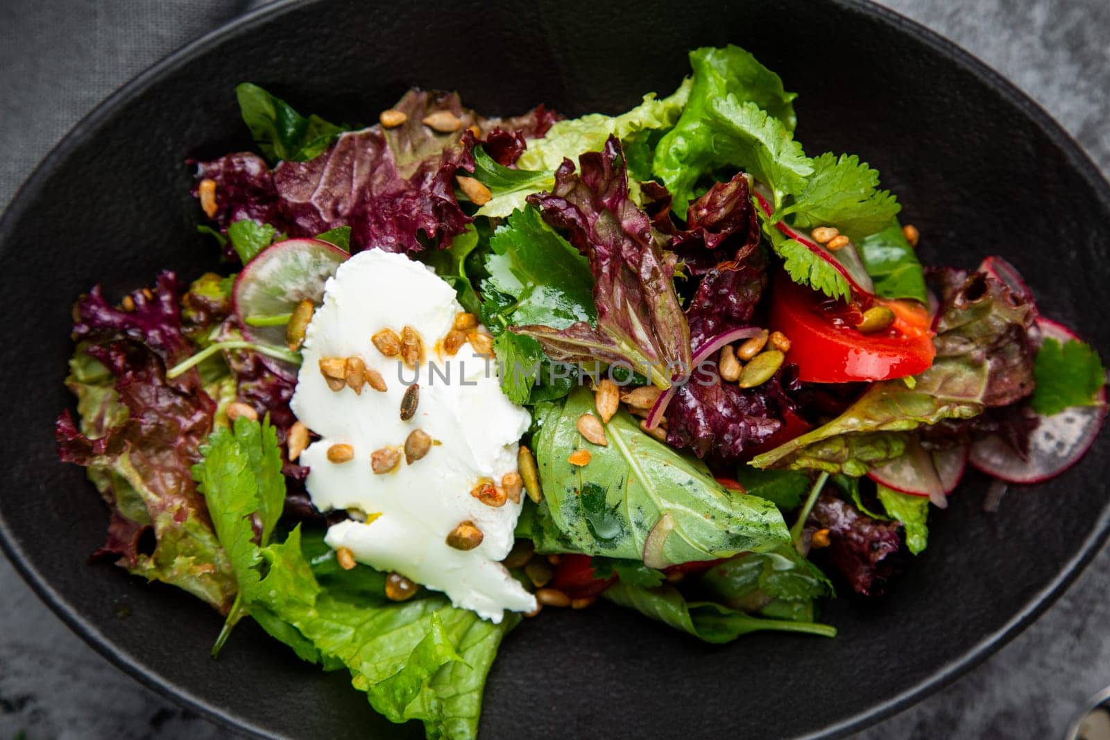 salad with lettuce, radishes, tomatoes, parsley, seeds and cheese side view by tewolf