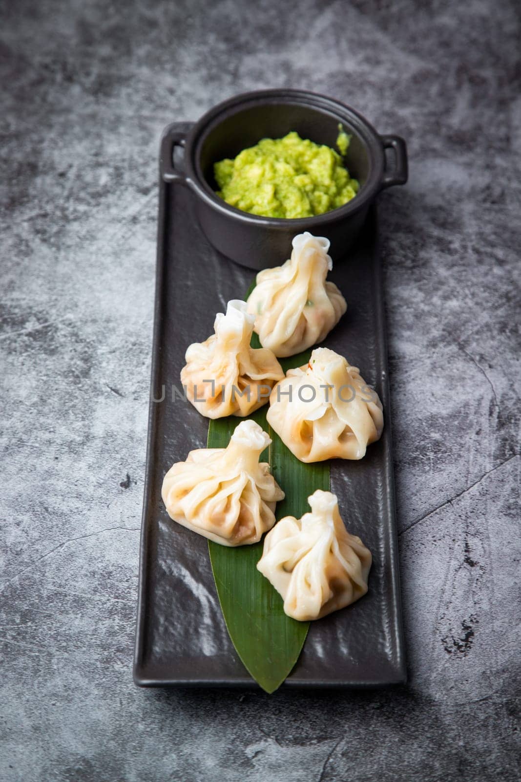 juicy khinkali with sauce on a black board side view by tewolf