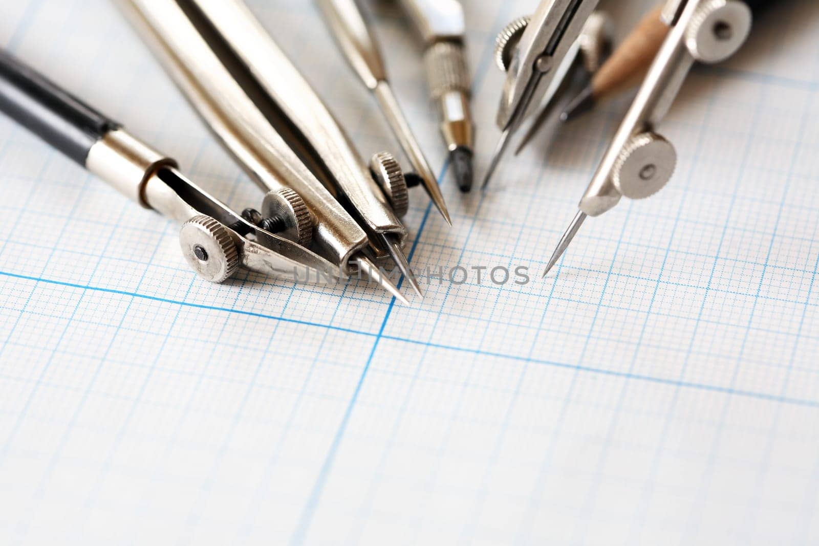 Set of old drawing tools on background with graph paper