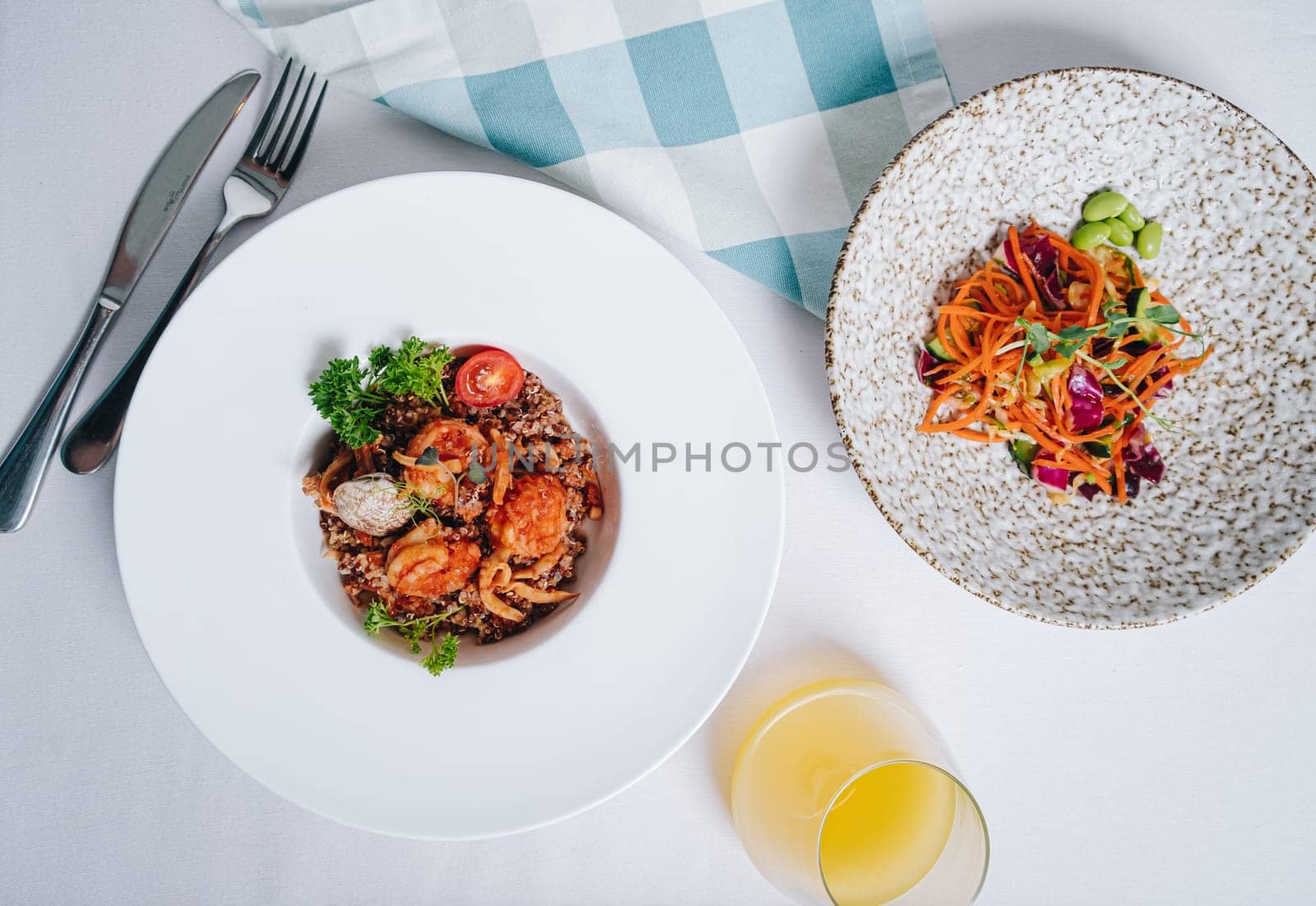 buckwheat with seafood, oyster, tomato and herbs in a deep plate side view by tewolf