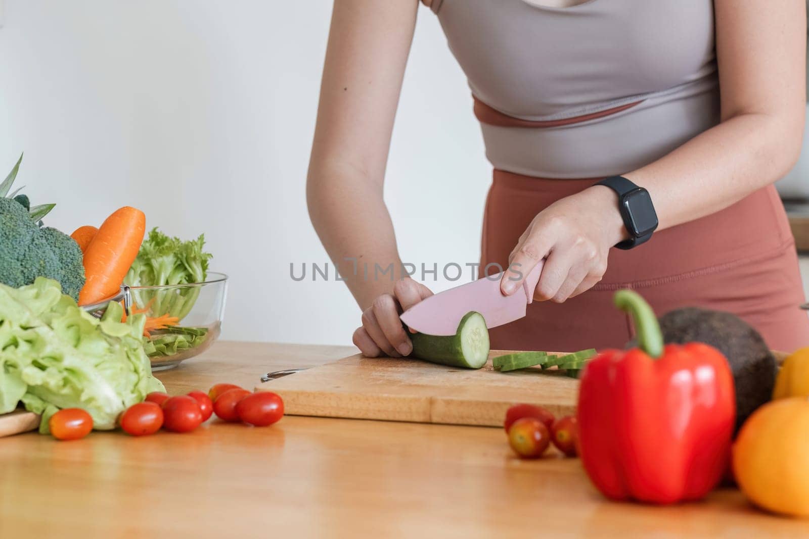 Sporty young woman is preparing healthy food on light kitchen. healthy food concept. by wichayada