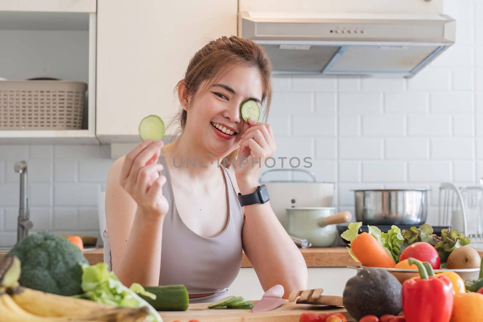 Sporty young woman is preparing healthy food on light kitchen. healthy food concept. by wichayada