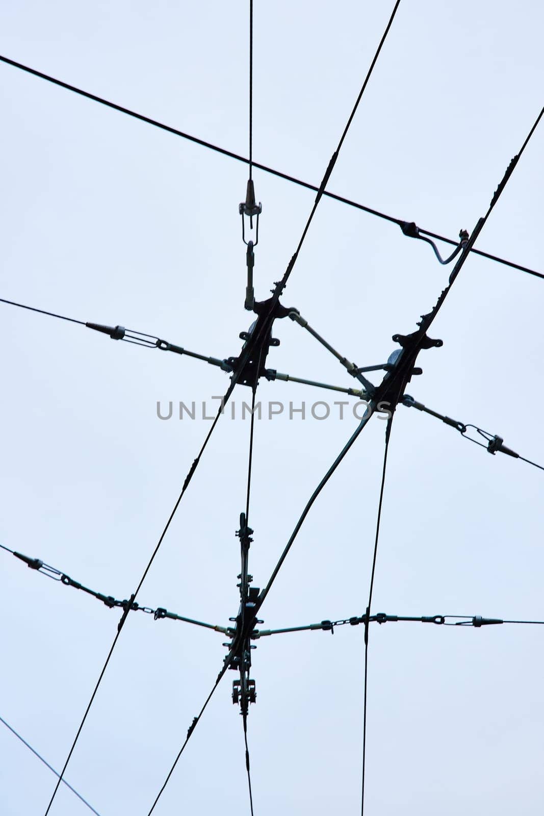 Image of Wires for city transportation clean electric energy upward abstract view with overcast sky