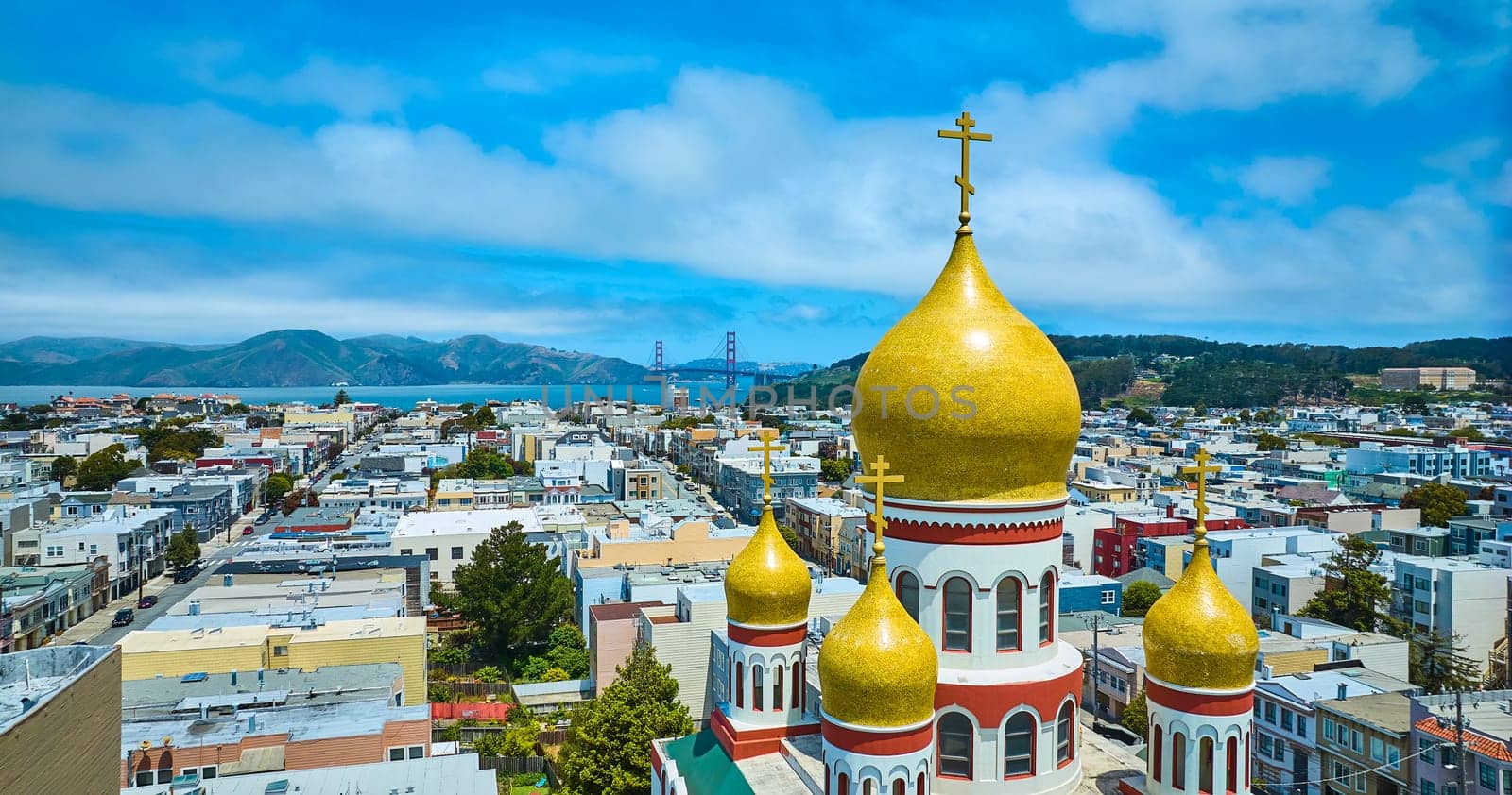 Image of Aerial domed roof of Russian orthodox Holy Virgin Cathedral with Golden Gate Bridge in distance