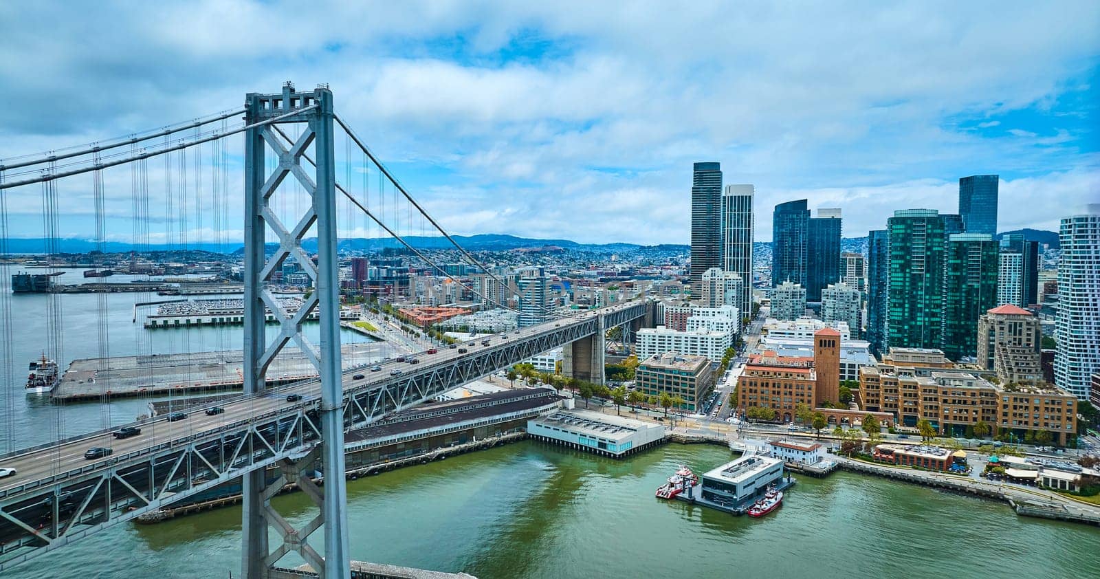 Image of Oakland Bay Bridge aerial with view of city skyscrapers and San Francisco Fire Department Pier