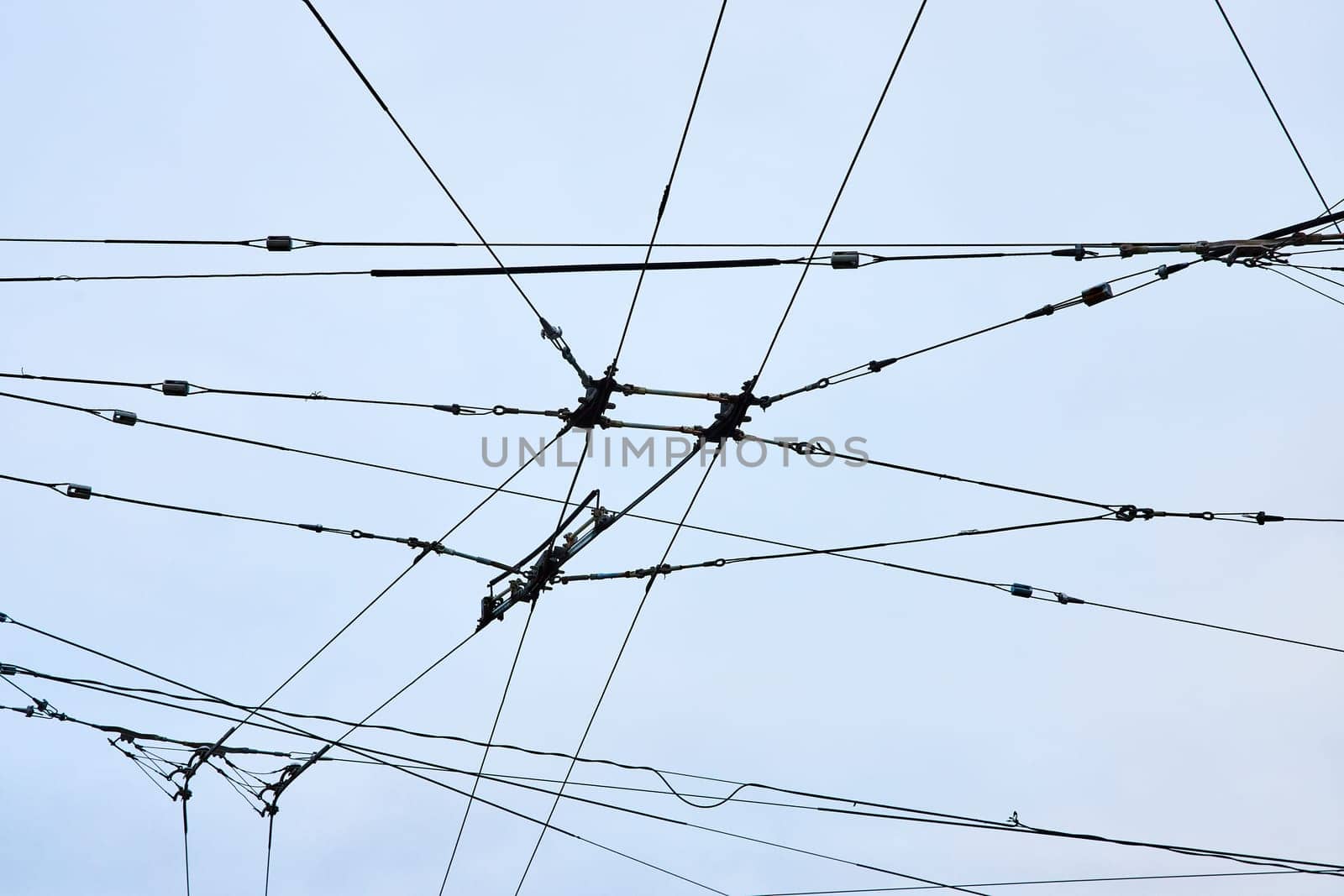 Image of Mess of wires for city transportation clean electric energy upward abstract view with overcast sky