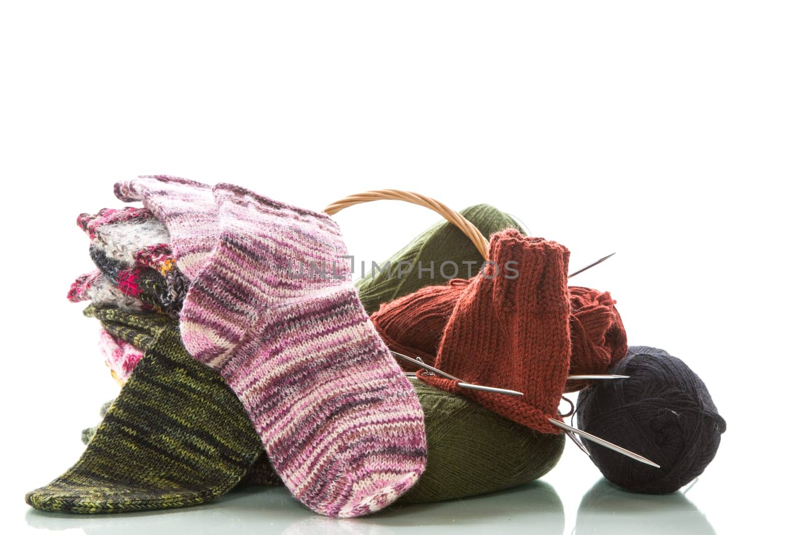 Colored threads, knitting needles and other items for hand knitting, isolated on a white background.