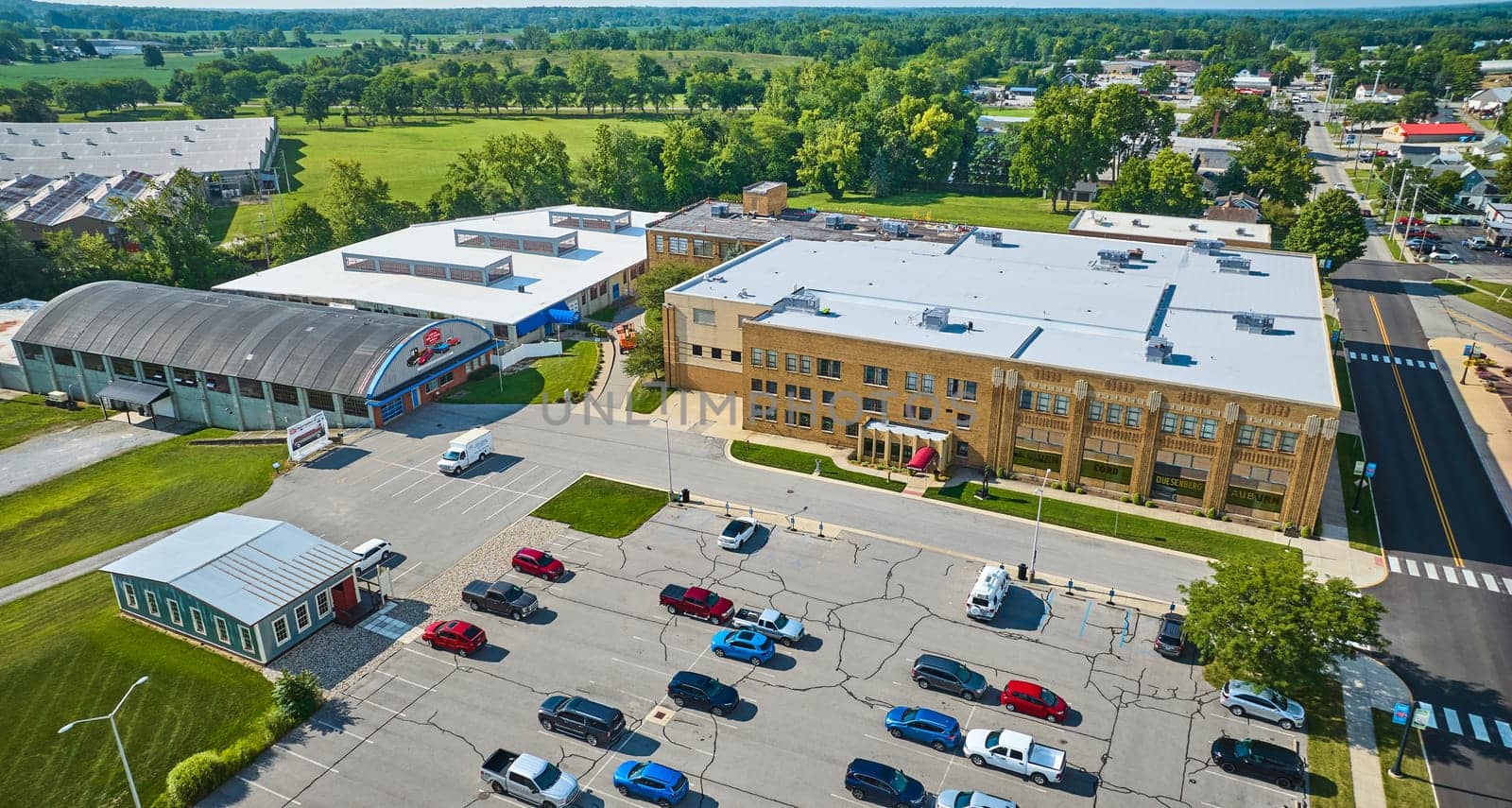 Image of Side entrance view of ACD Automobile Museum with parking lot on bright sunny day aerial