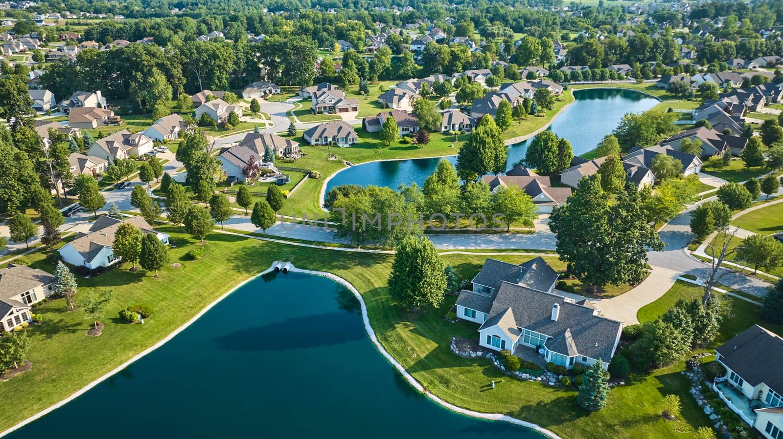 Image of Large neighborhoods with two ponds and multiple houses aerial