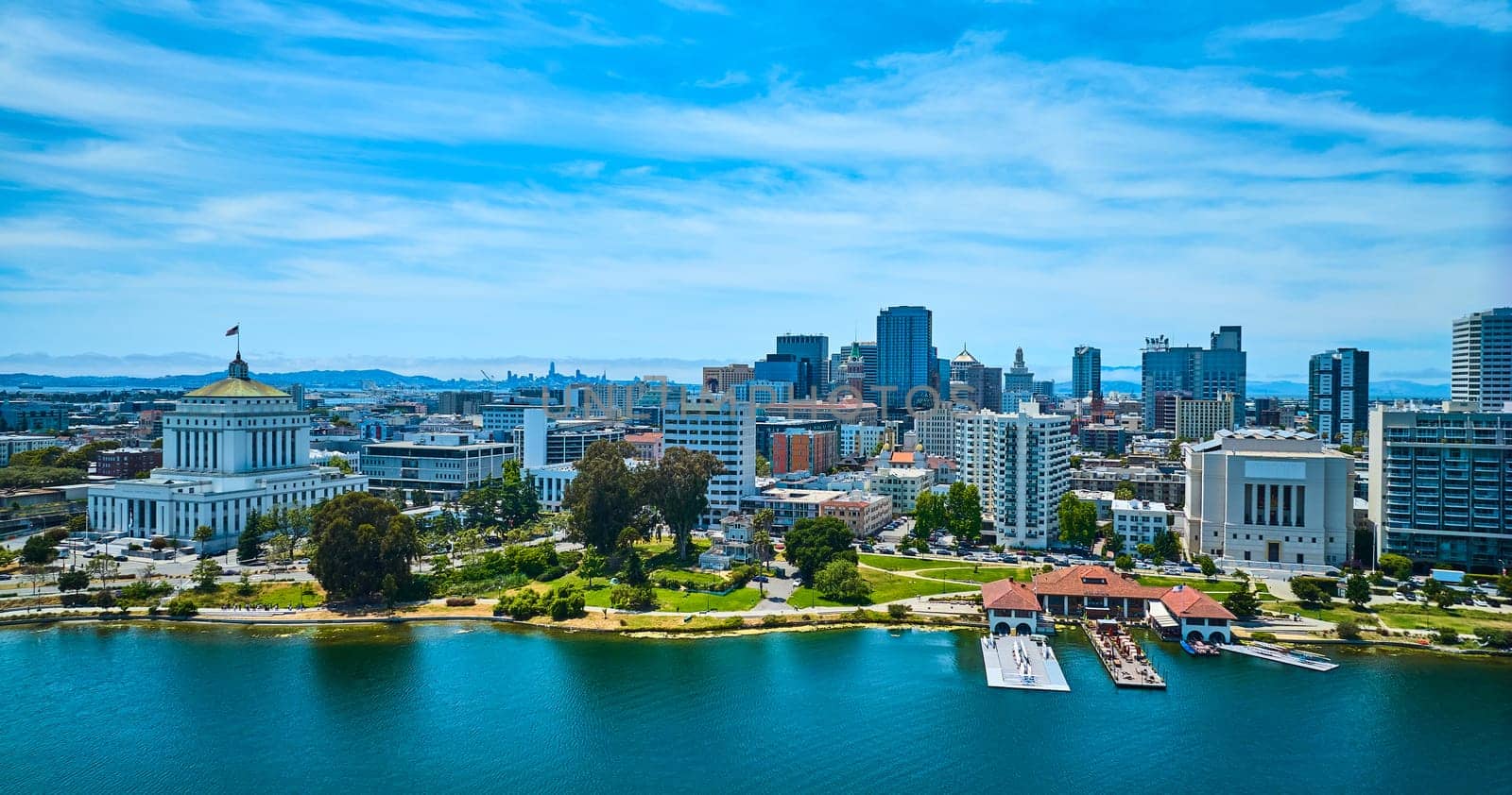 Image of Low aerial of Oakland restaurant and downtown skyscrapers with courthouse