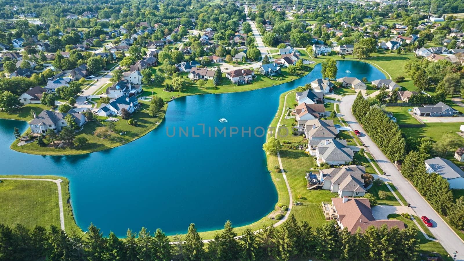 Image of Wide view of expensive neighborhood with large pond and two water fountains