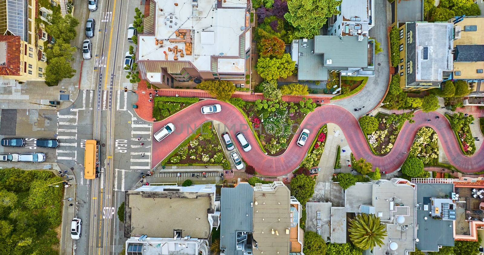 Image of Straight down view Lombard Street top of hill with cars driving down red brick road aerial