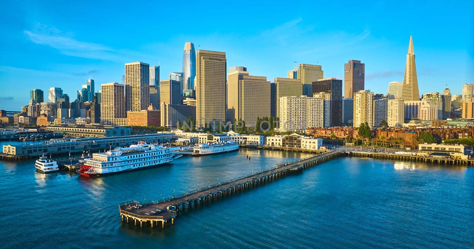 Image of Aerial Pier 7 at sunrise with San Francisco skyscraper skyline and boats docked in bay