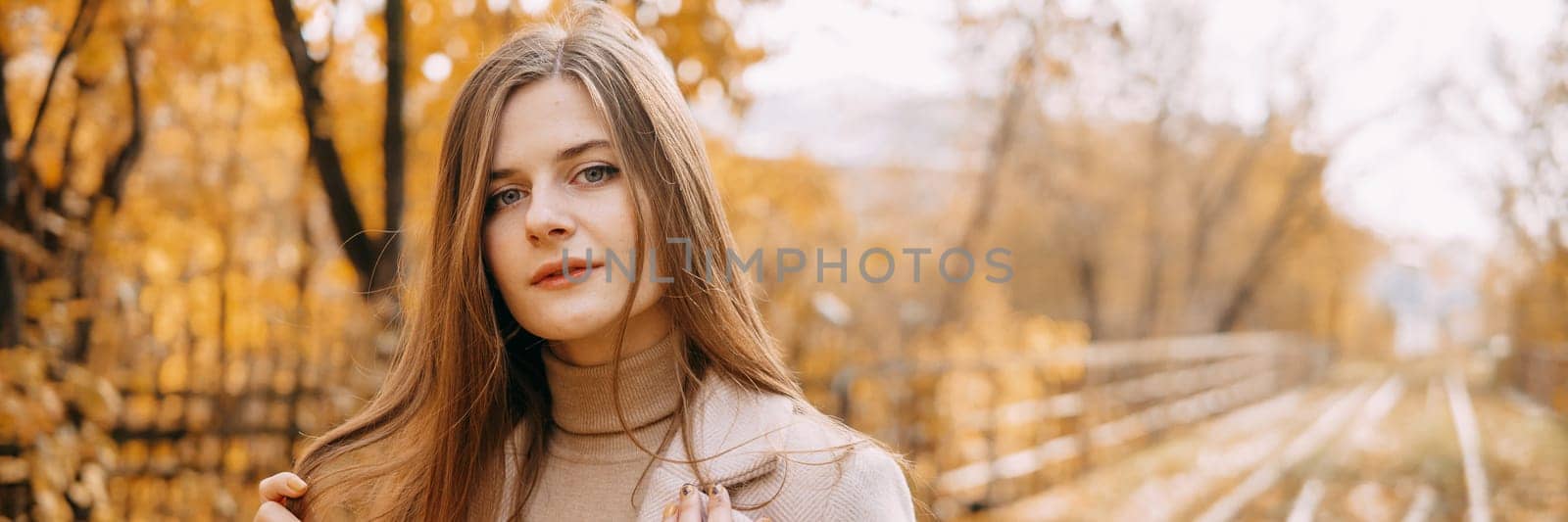 beautiful long-haired woman walks through the autumn streets. Railway, autumn, woman in a coat. by Annu1tochka