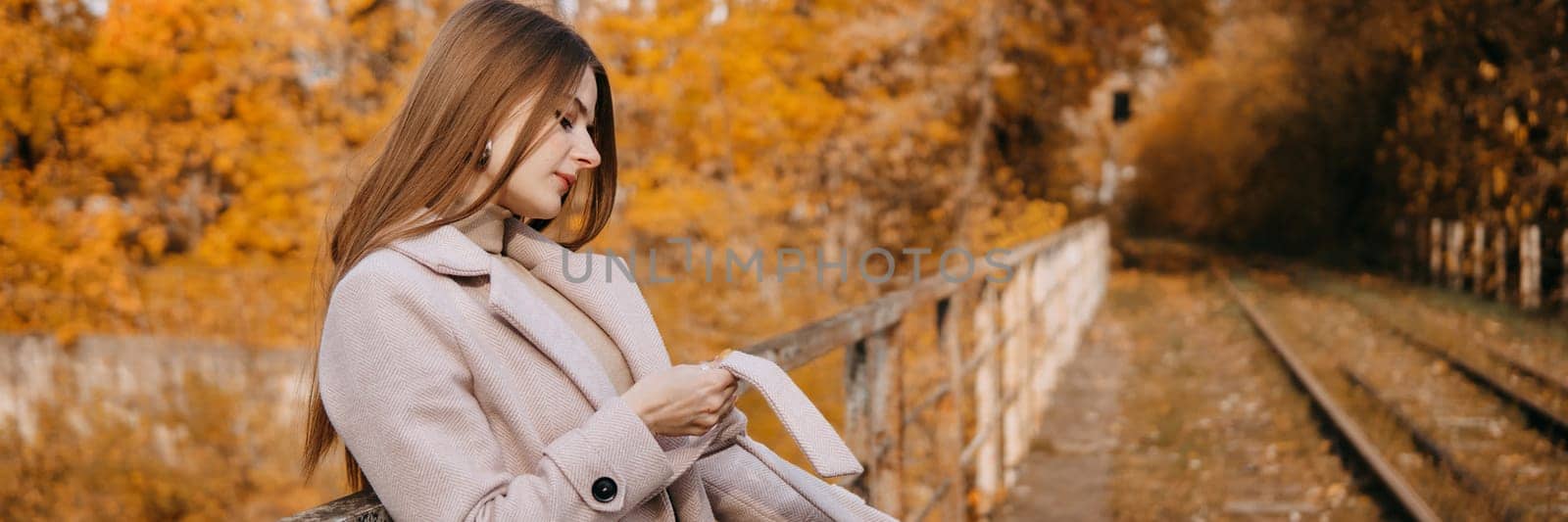 beautiful long-haired woman walks through the autumn streets. Railway, autumn, woman in a coat. by Annu1tochka