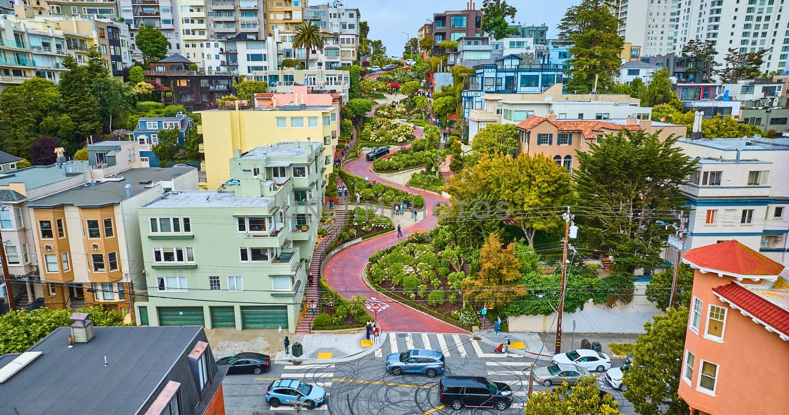 Image of Aerial straight on shot of Lombard Street with cars and people winding down road lined by houses