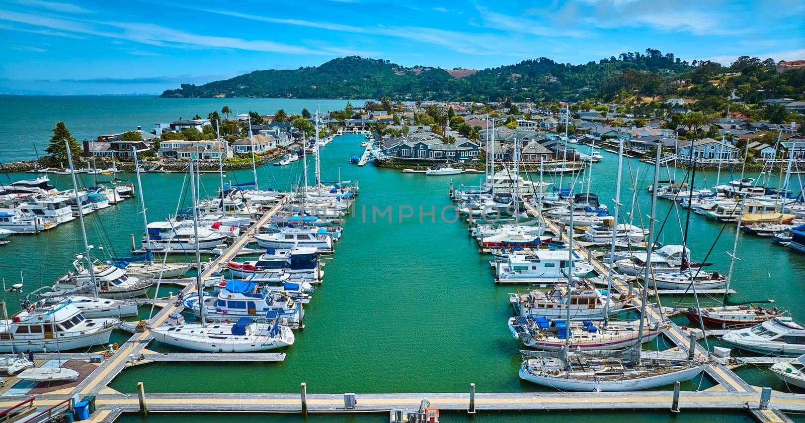 Image of Aerial boats on teal water with waterfront properties behind in Paradise Cay Yacht Harbor