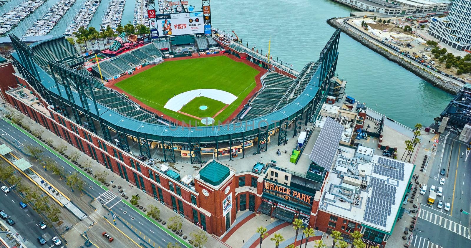 Image of Oracle Park downward aerial of Willie Mays Gate entrance with people on field