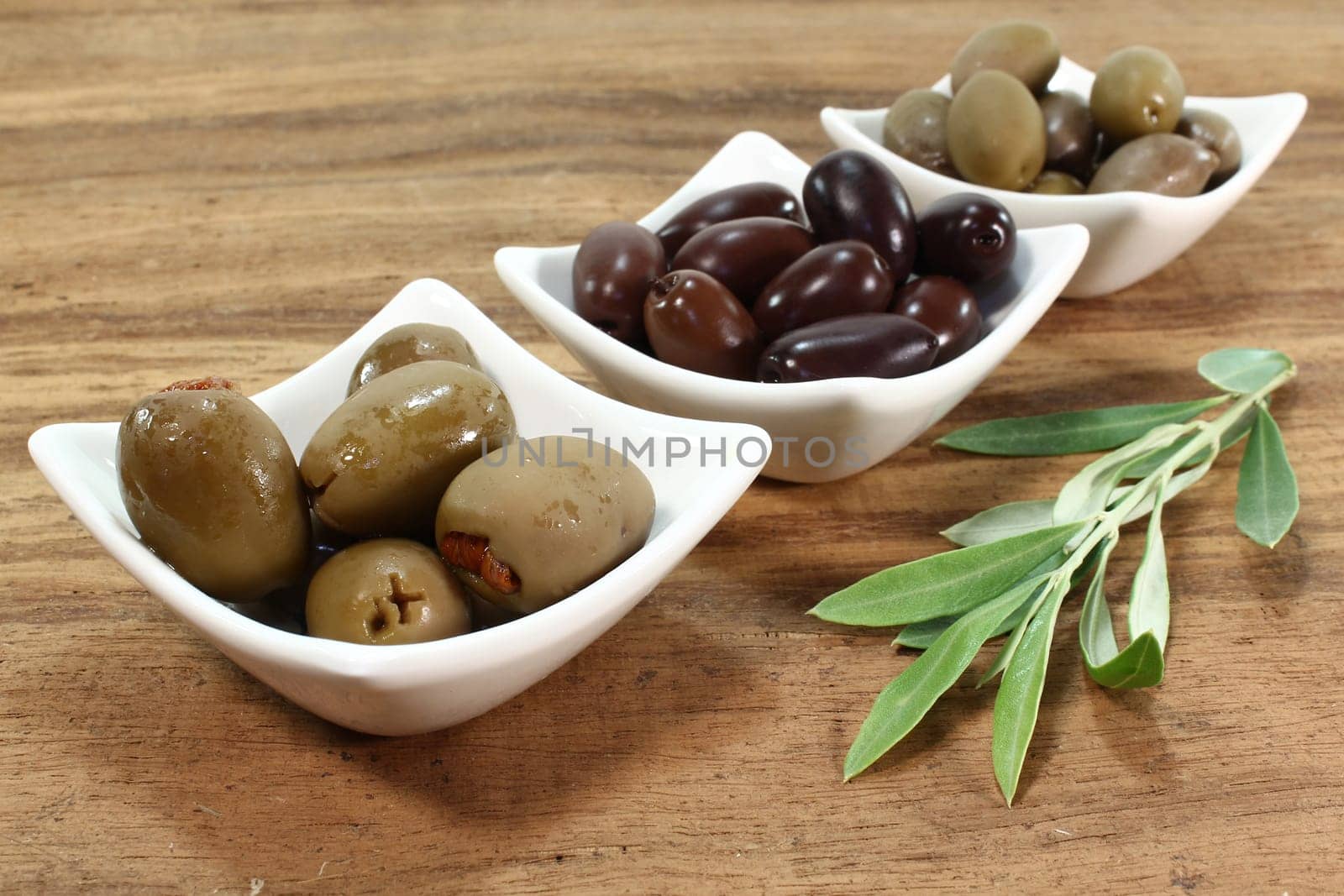 different varieties of olives with olive branch