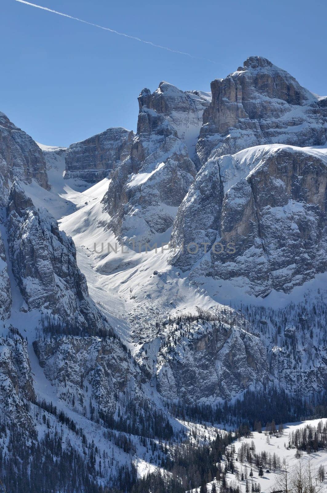 view of famous valley in dolomites with steep cliffs and snowy slopes, shot in bright winter light from the north side of the mountain