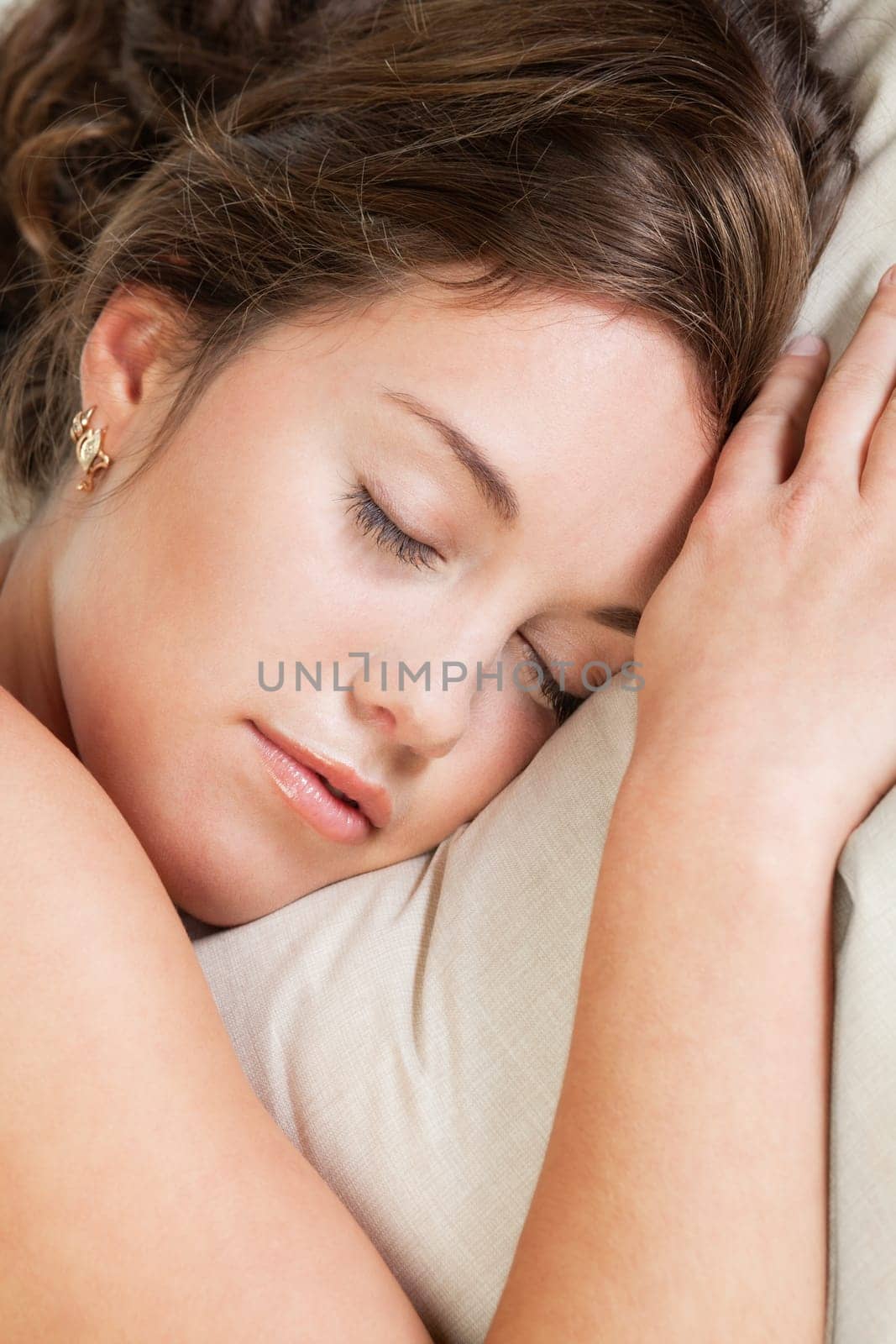 Pretty young woman sleeps in her bed
