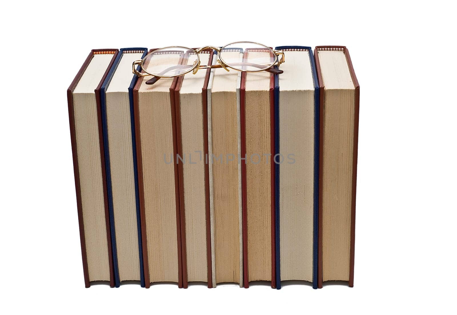 Old books and a pair of glasses isolated over a white background.