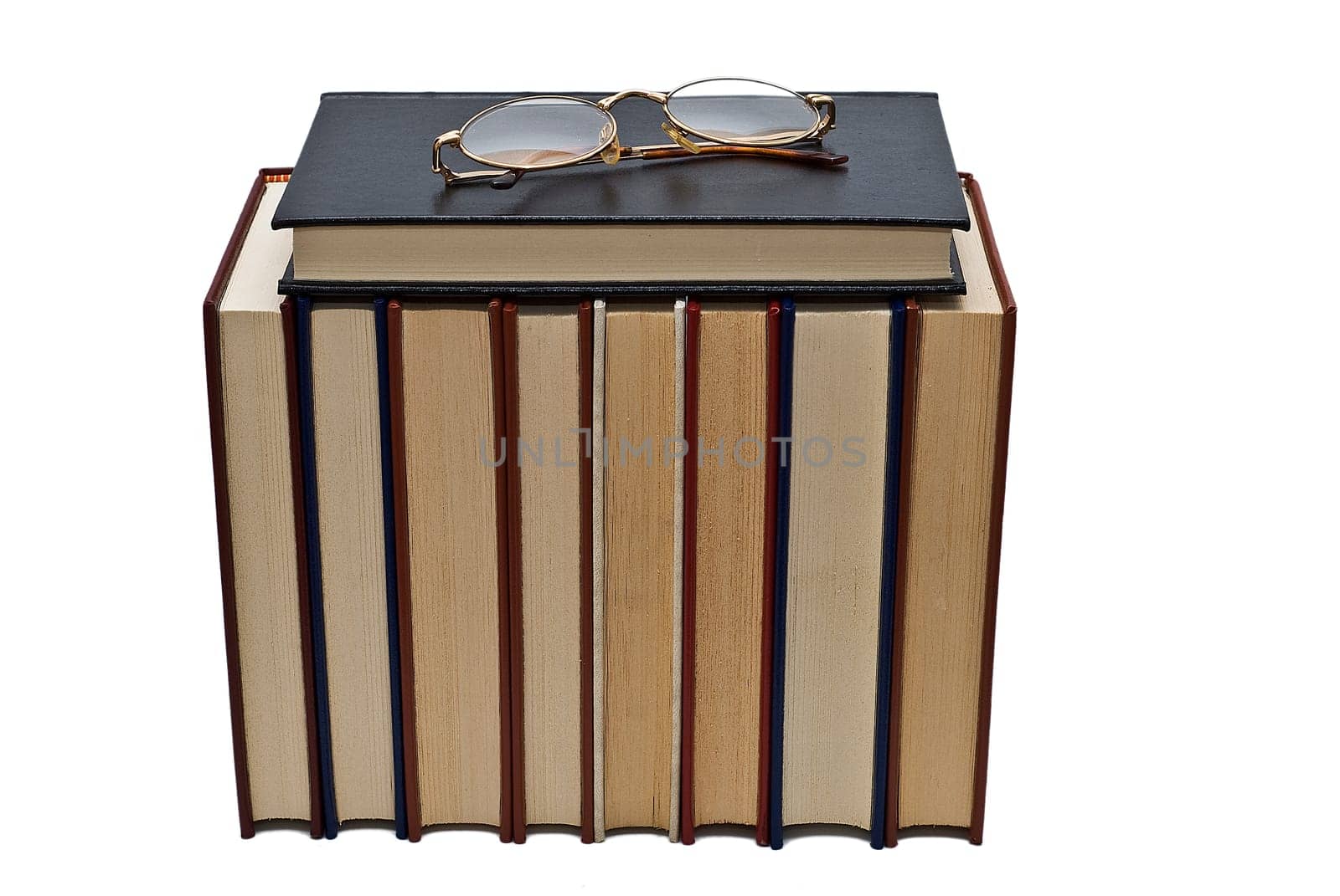 Old books and a pair of glasses isolated over a white background.