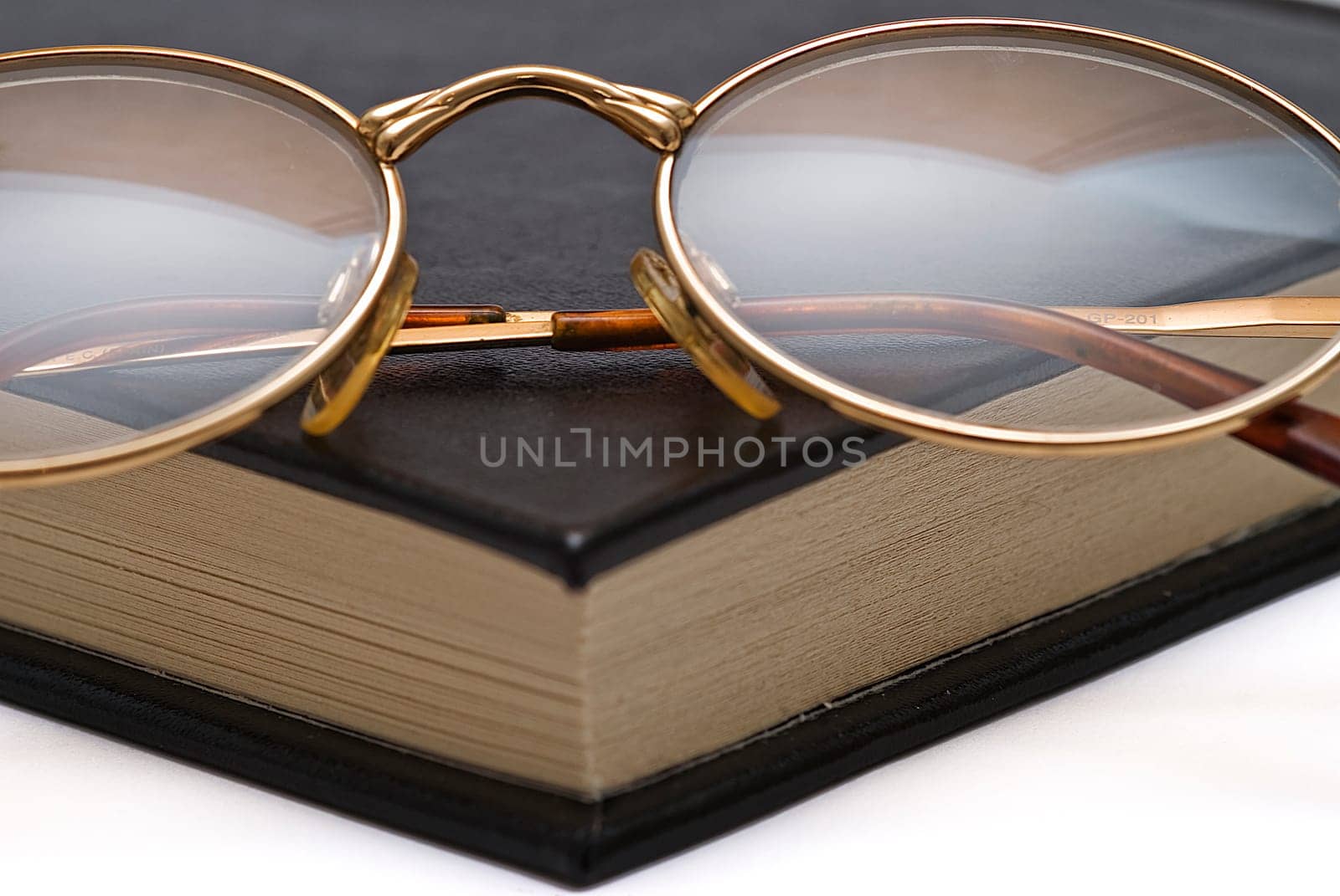 Old books and a pair of glasses isolated over a white background.