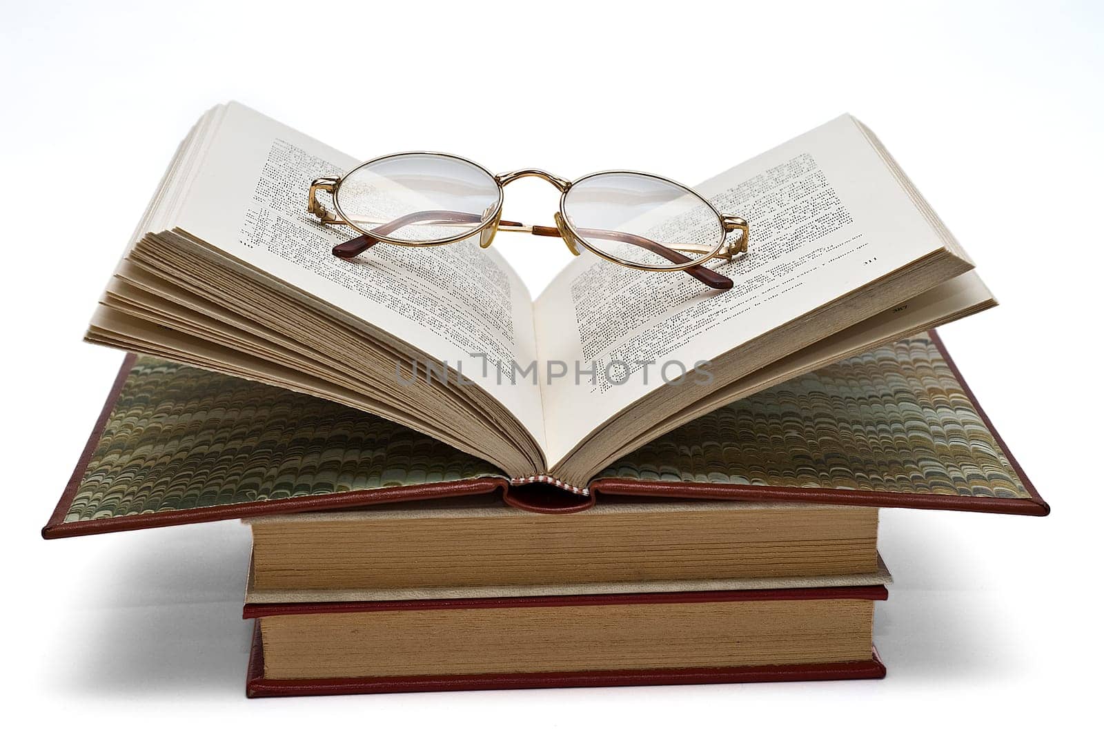 Old books and a pair of glasses isolated over a white background.