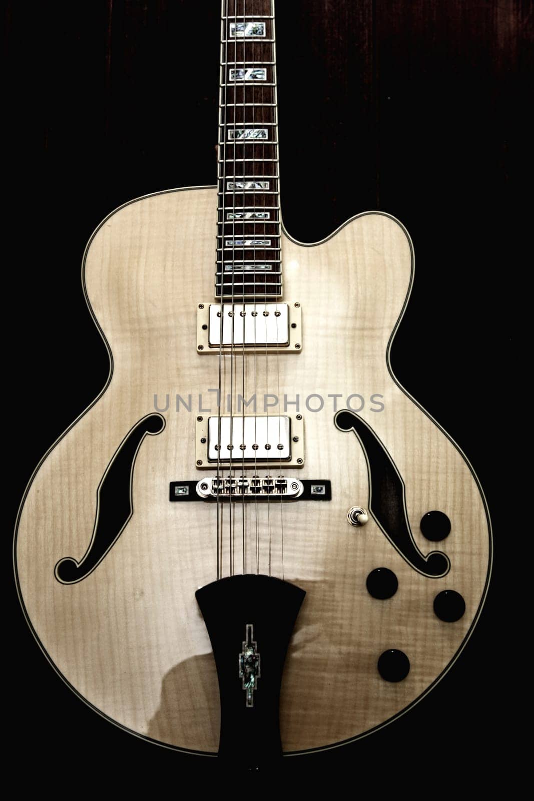 Ivory electric guitar against black background