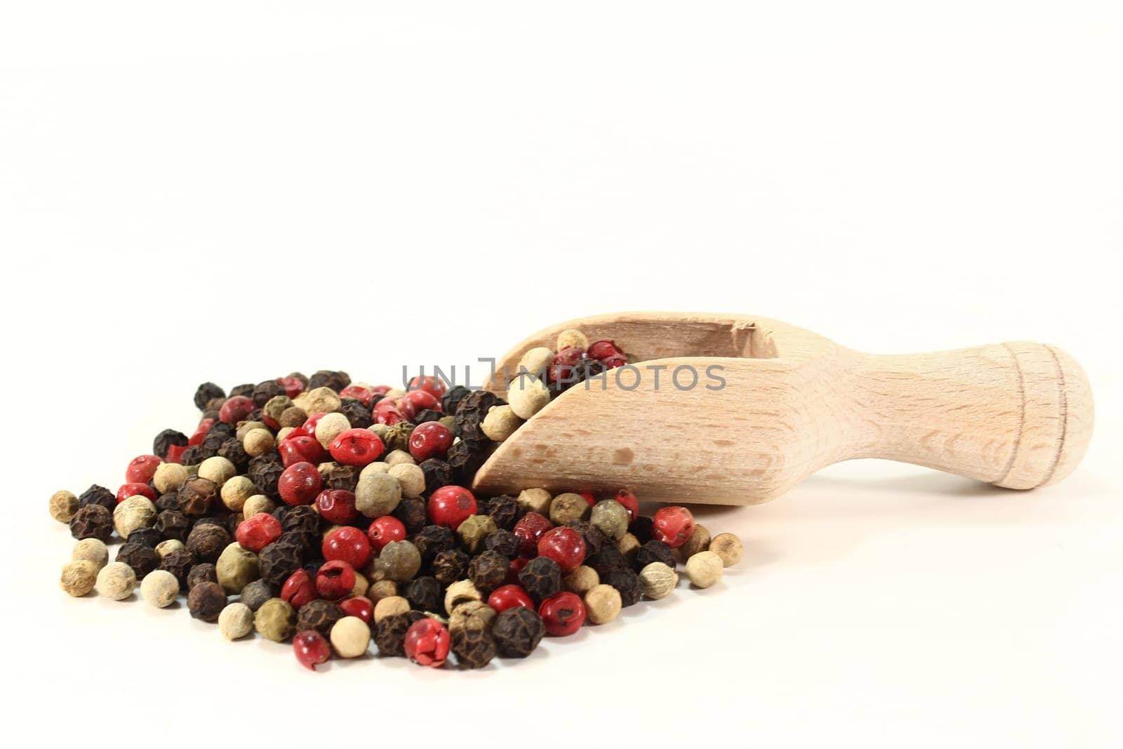 Colorful pepper with small scoop against white background