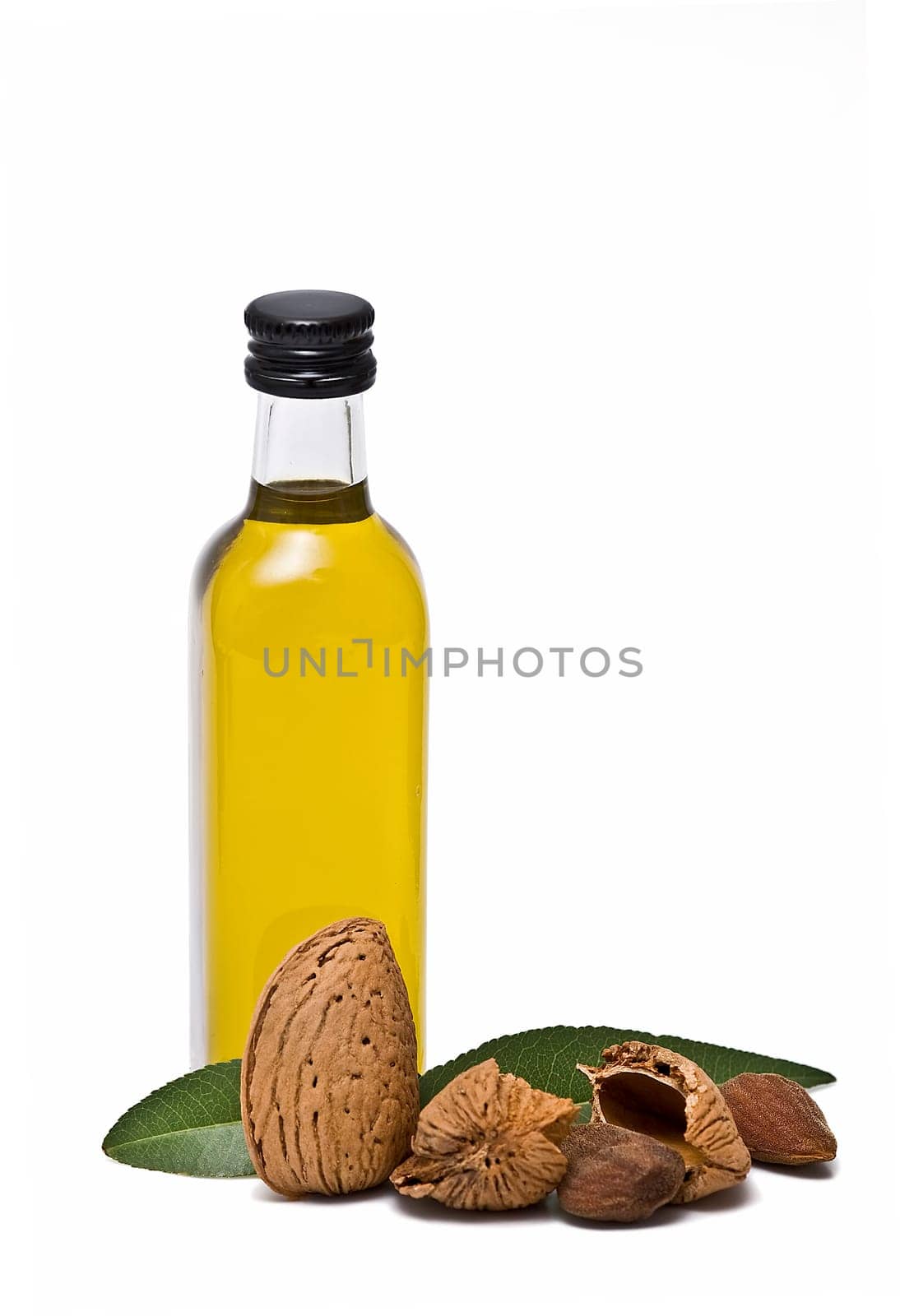Almonds and a bottle of almond oil isolated over a white background.