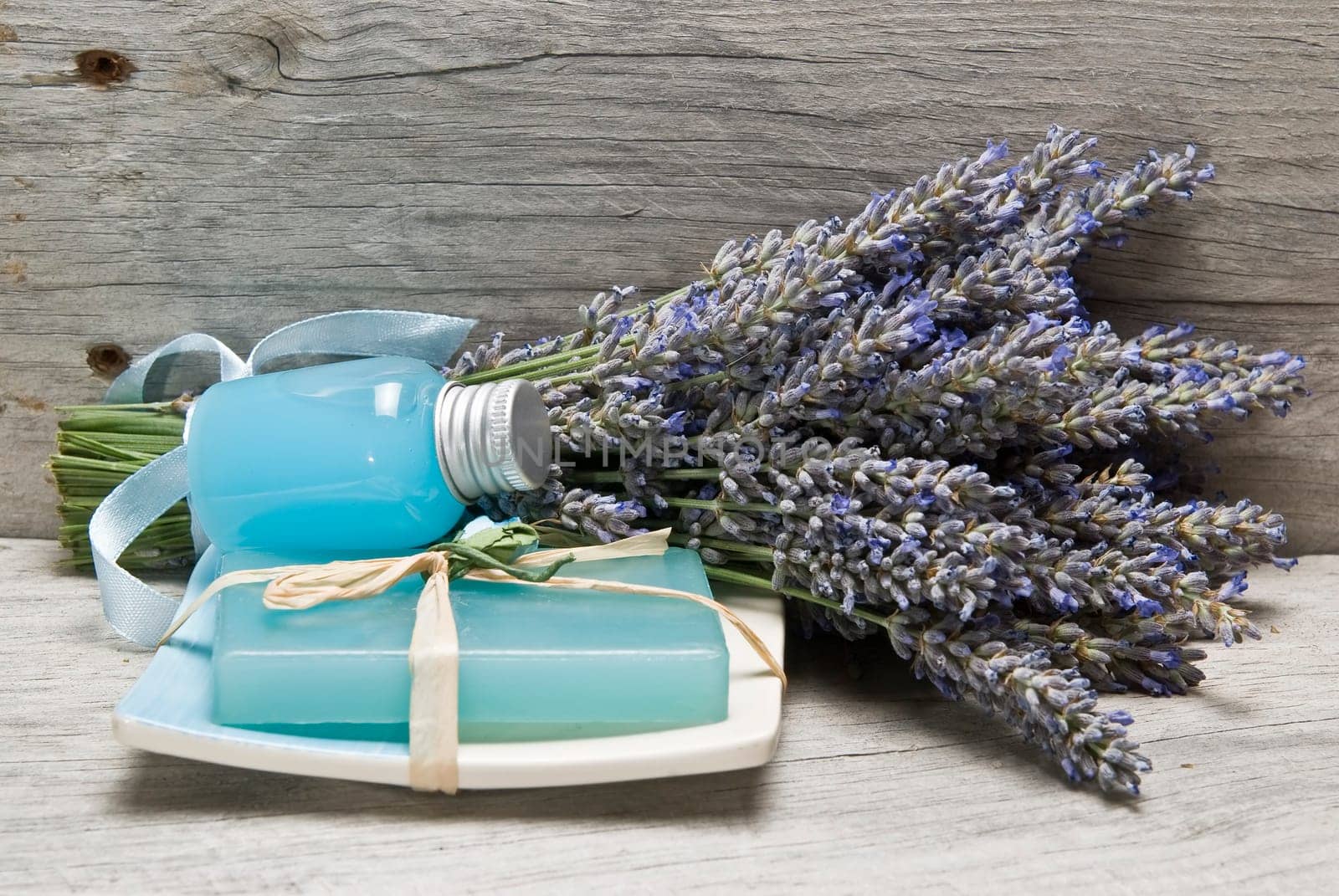 Lavender and some hygiene items made of lavender on an old wooden shelf.