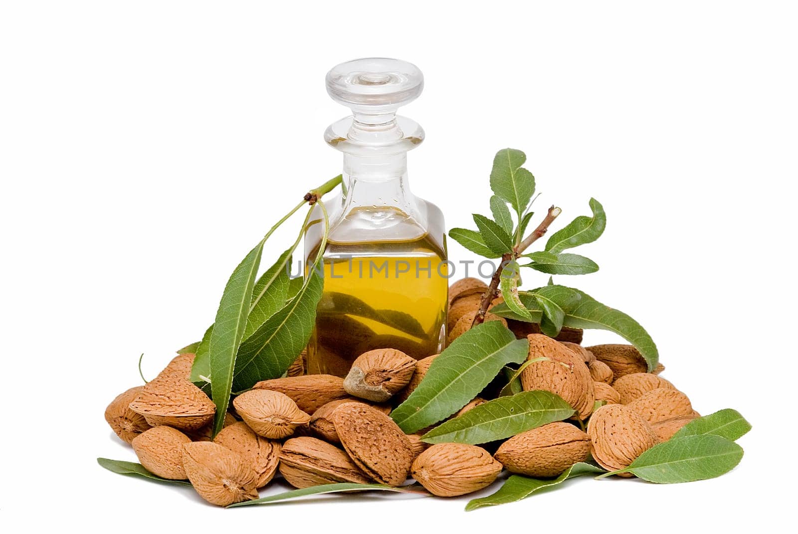 Almonds and a bottle of almond oil isolated over a white background.