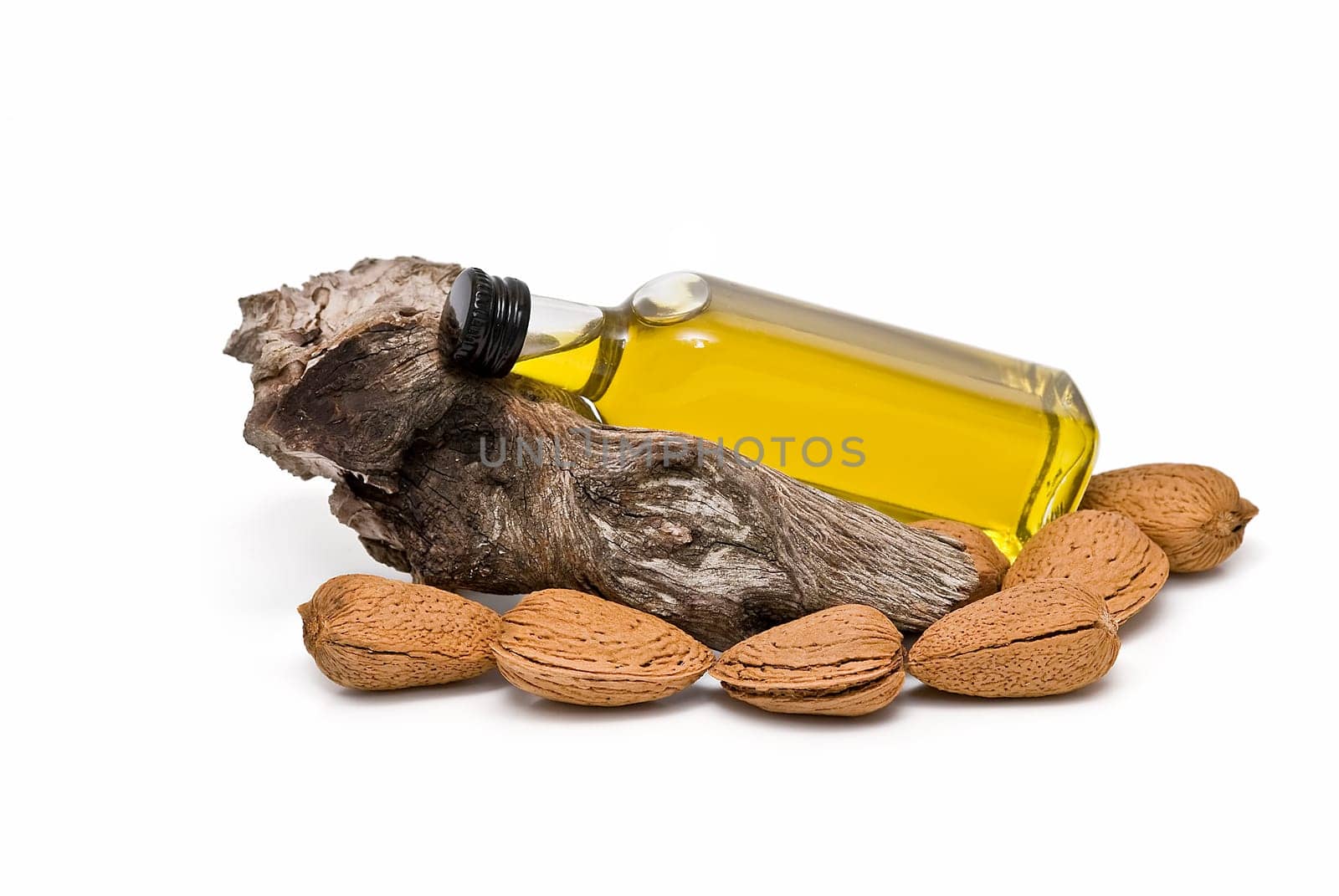 Almonds and a bottle of almond oil isolated over a white background.
