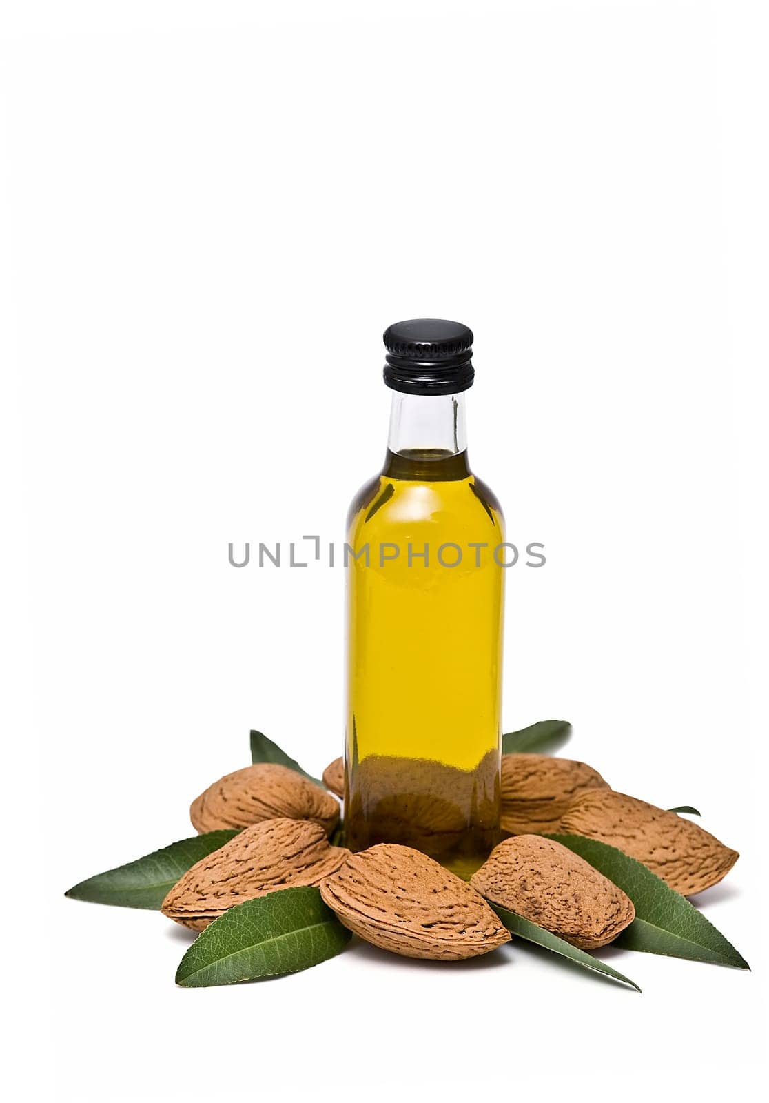 Almonds and a bottle of almond oil isolated over a white background.