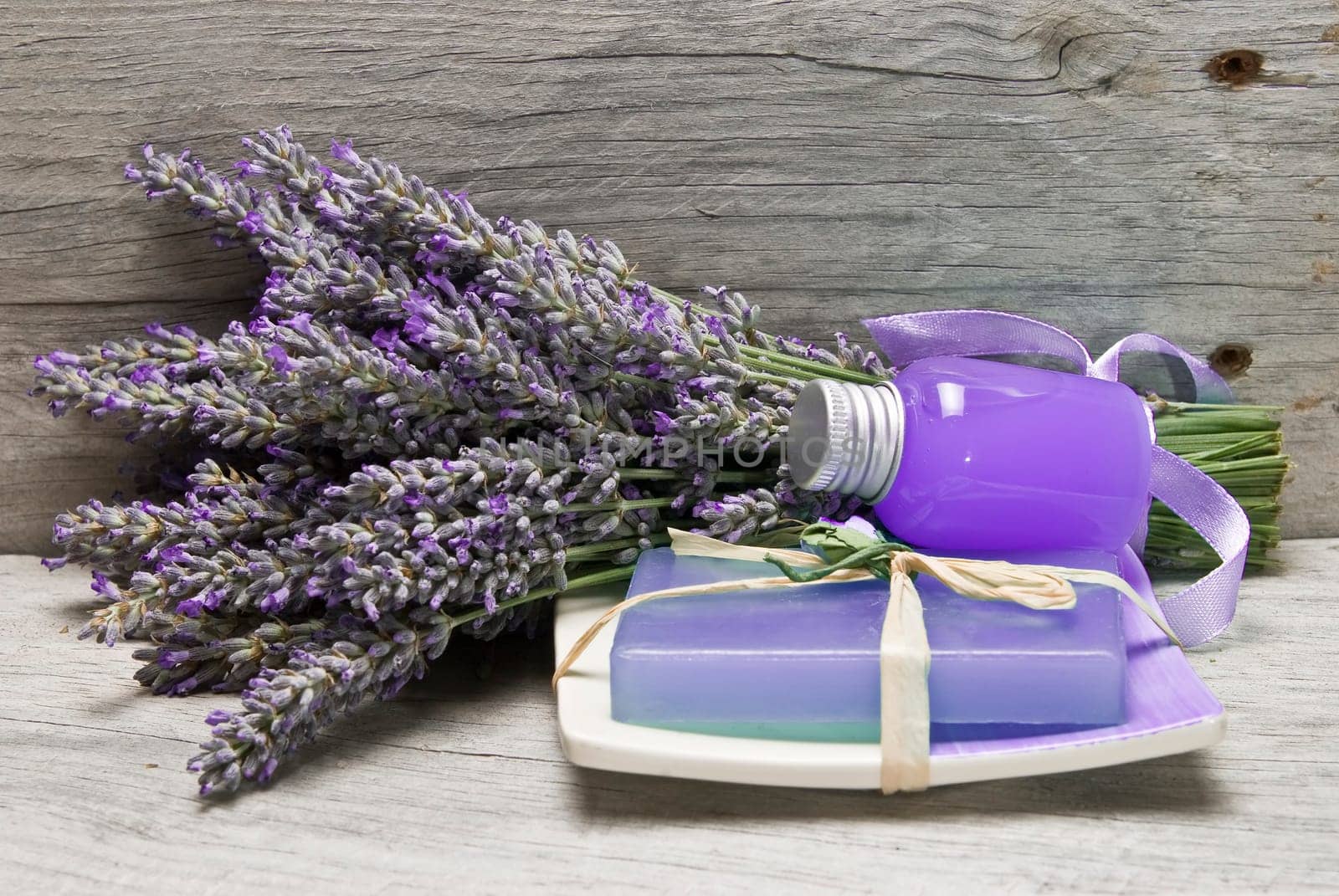 Lavender and some hygiene items made of lavender on an old wooden shelf.