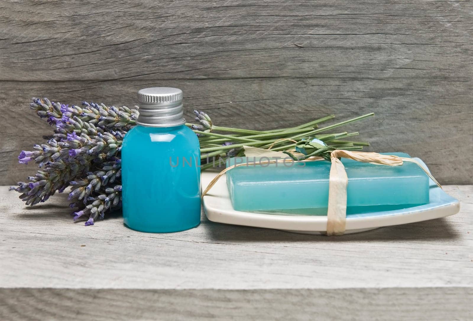 Lavender and some hygiene items made of lavender on an old wooden shelf.