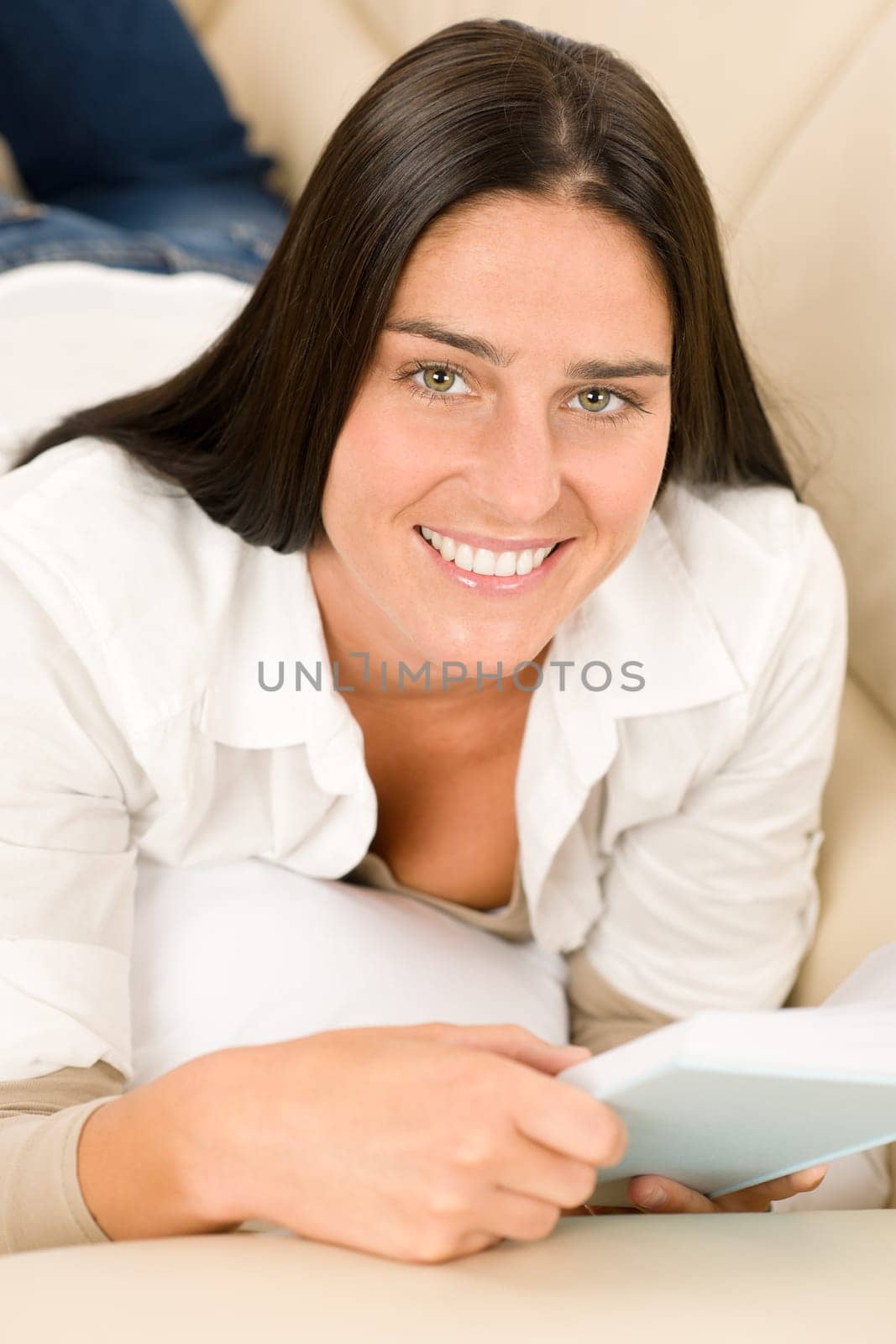 Smiling mid-aged woman read book on sofa in lounge